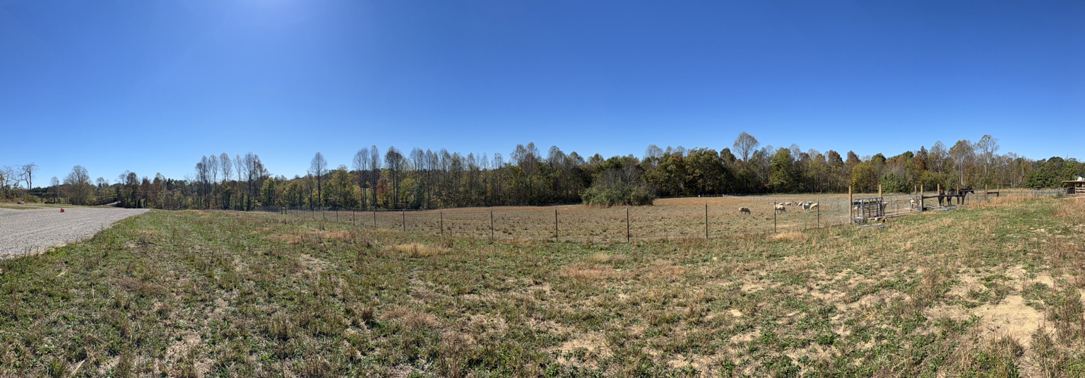 Panoramic view of the open campground and gravel site area